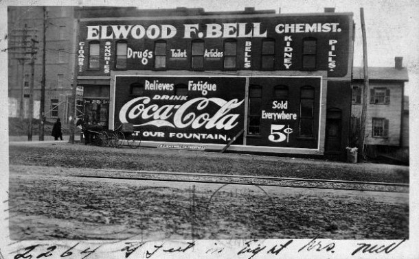 Elwood F. Bell, Chemist, office covered with Coca-Cola and other ads 1911